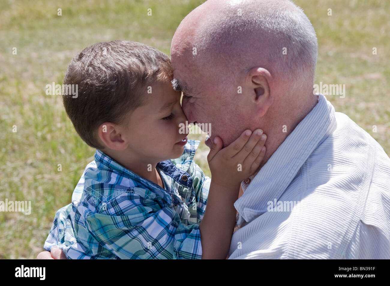 Eldery homme jouant de pincer le nez avec son petit-fils Banque D'Images