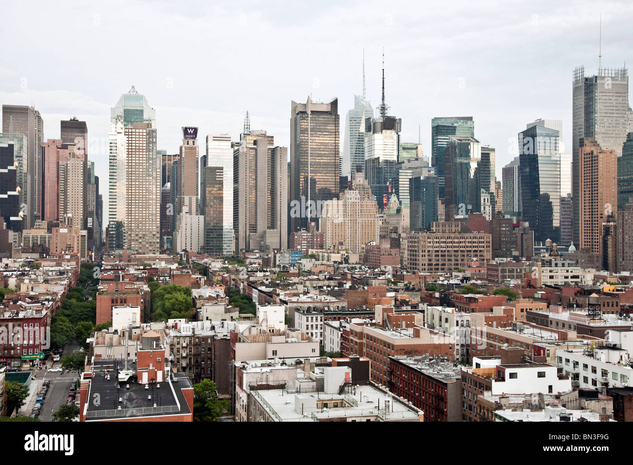 Vue vers l'est au coucher du soleil au niveau des toits de vieux logements dans la région de Hells Kitchen à la mi Manhattan skyline towers de la 8e Avenue et Broadway NYC Banque D'Images