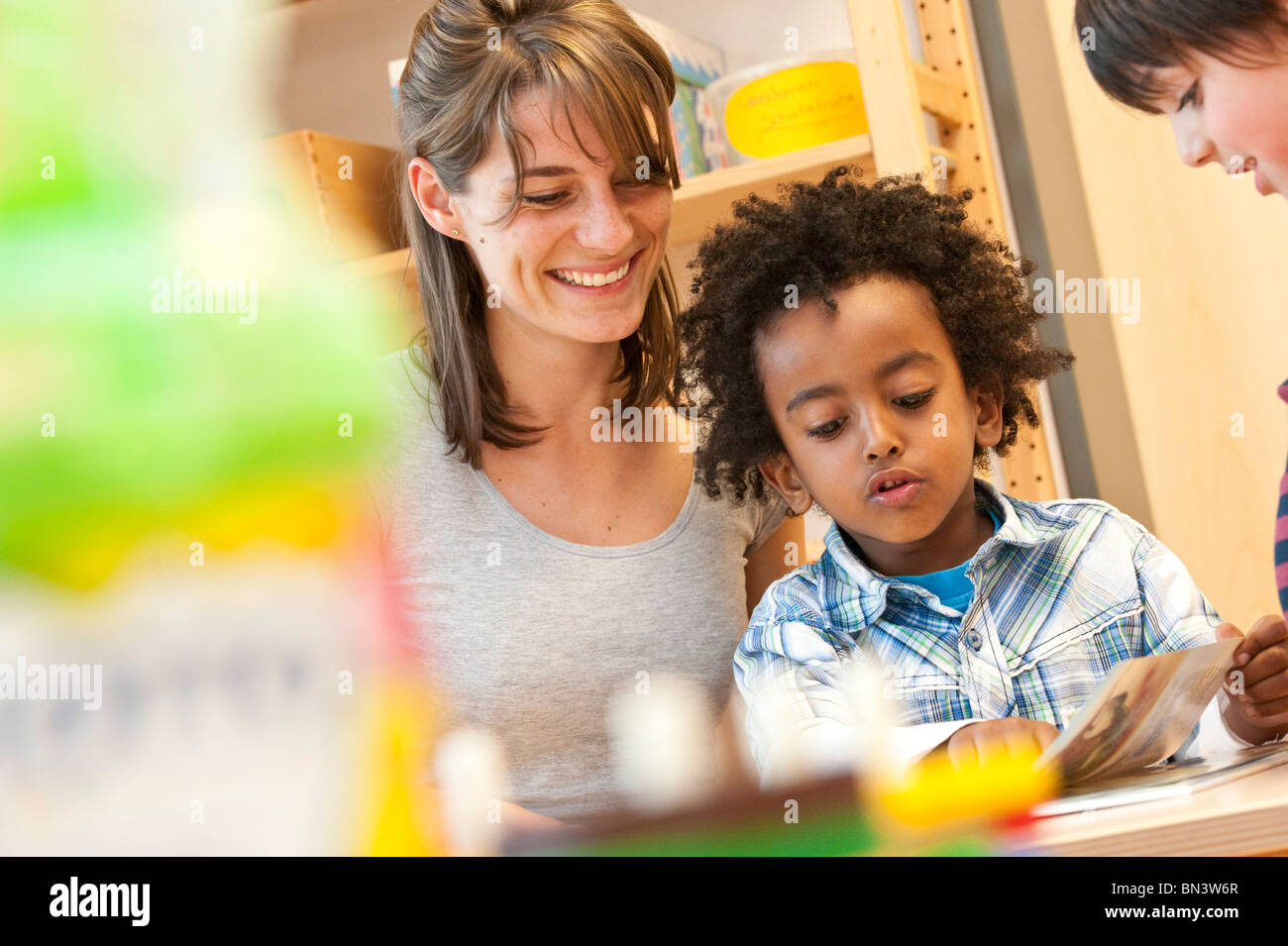 Enseignant de maternelle et les enfants à la recherche de livre, low angle view Banque D'Images