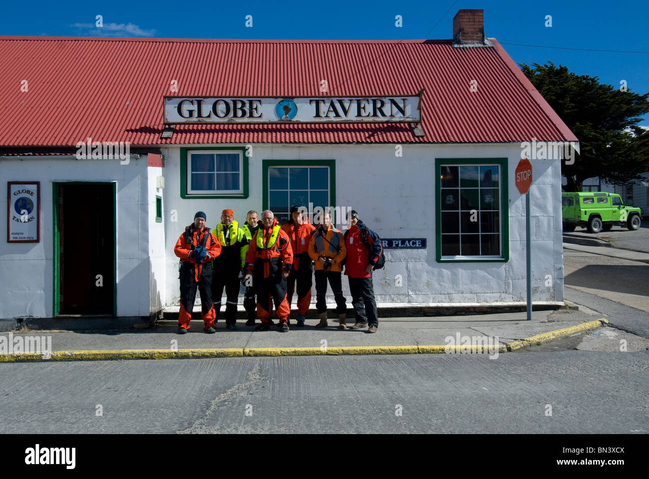 Groupe d'hommes en face du Globe Tavern, Stanley, East Falkland Banque D'Images