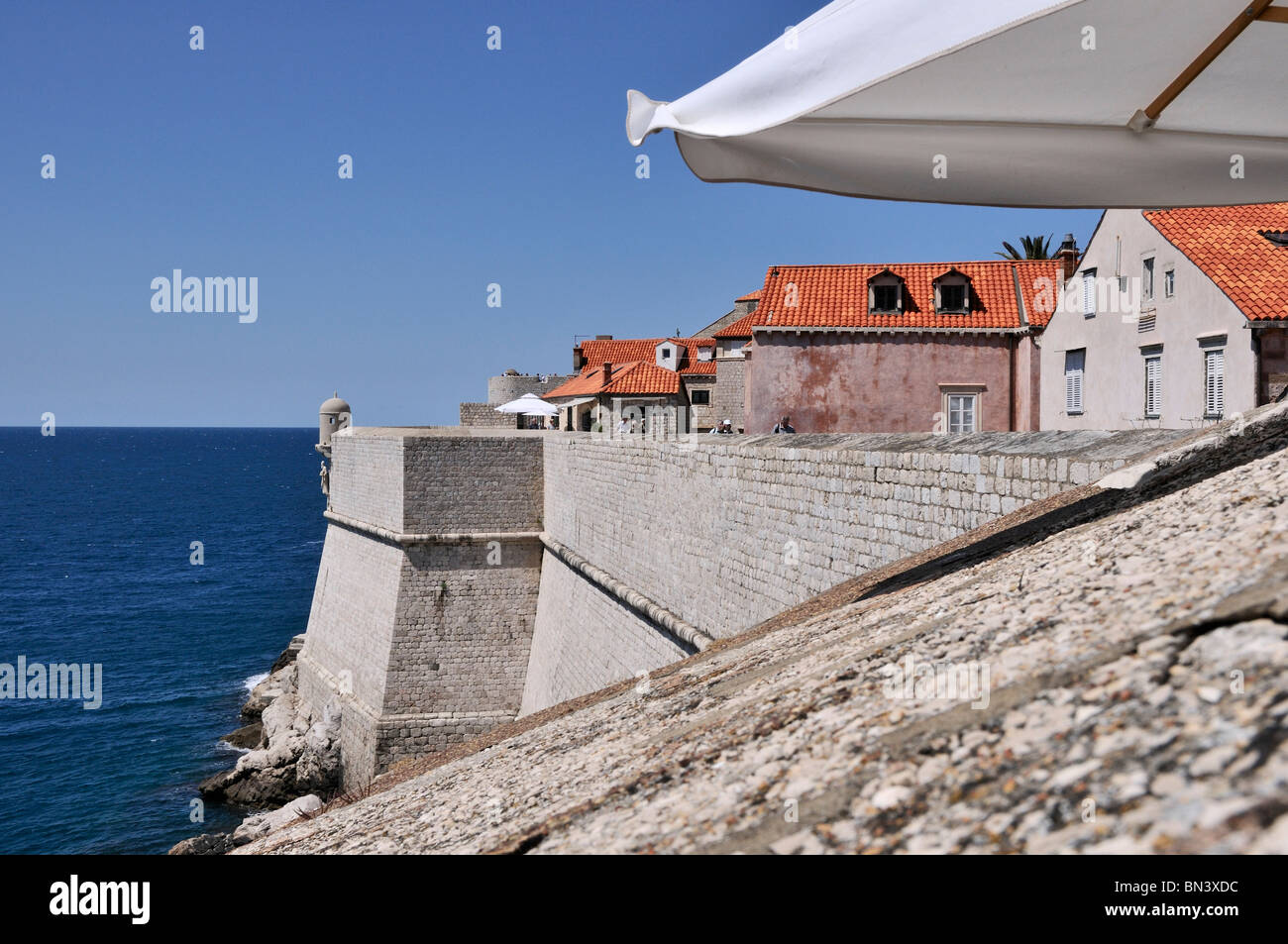 Red Roof maisons de la vieille ville se tenir dans les murs de protection qui s'élèvent de la mer bleue, Dubrovnik Banque D'Images