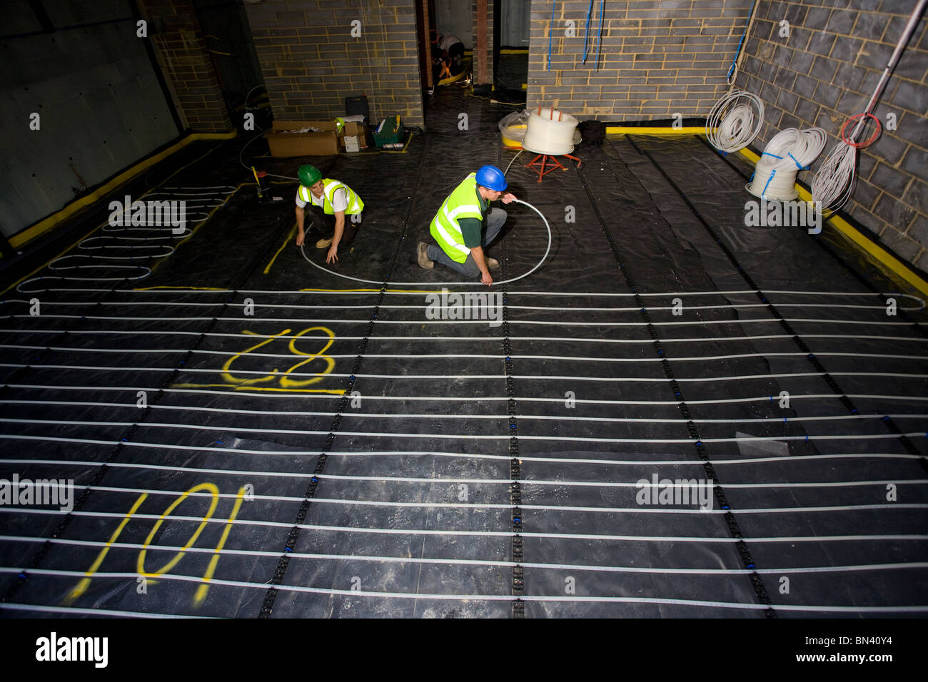 Ouvriers installer le chauffage par le sol dans une nouvelle propriété. Photo par James Boardman. Banque D'Images