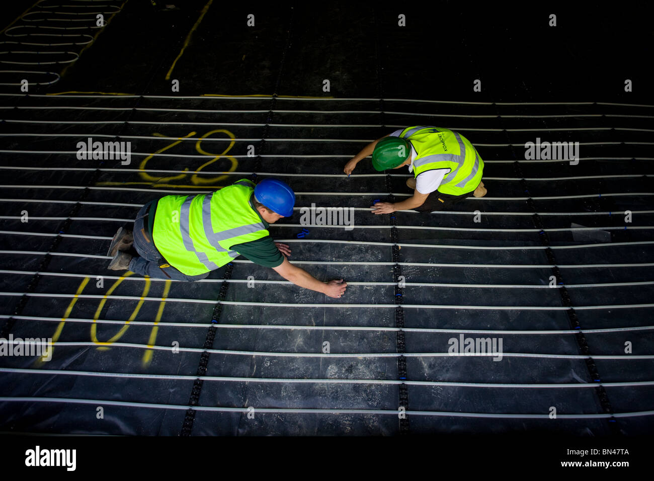 Ouvriers installer le chauffage par le sol dans une nouvelle propriété. Photo par James Boardman. Banque D'Images
