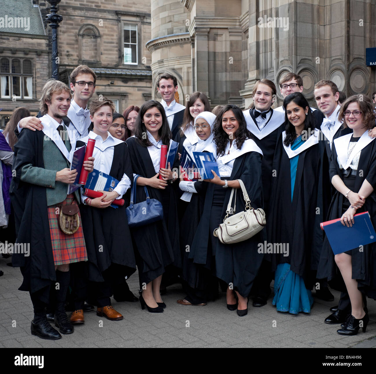 Groupe de femmes et d'hommes multiculturels les élèves qui sortent de l'Université d'Edimbourg, Ecosse, Royaume-Uni, Europe Banque D'Images