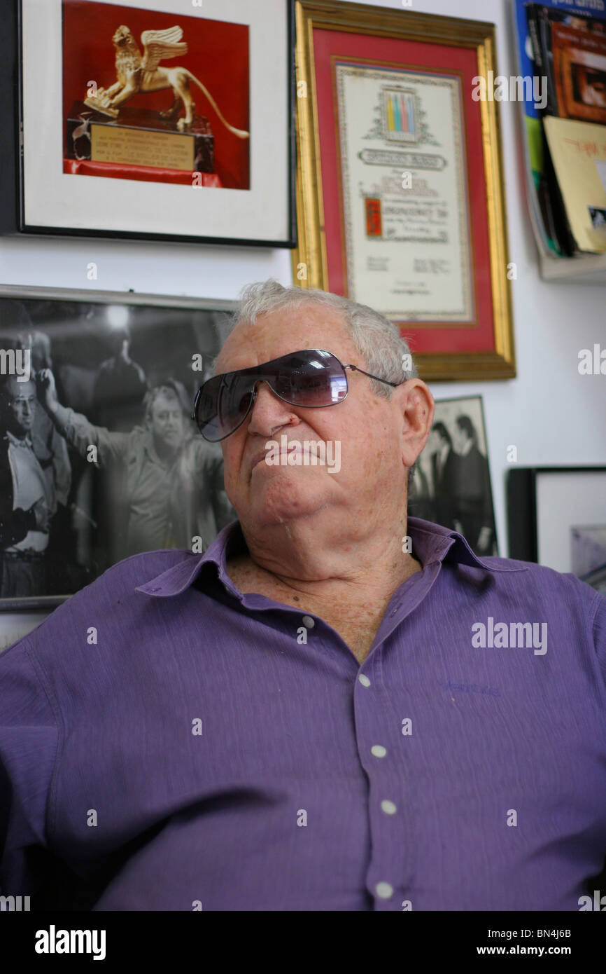 Producteur et réalisateur israélien Menahem Golan regarde ses nombreuses récompenses, accroché au mur de son bureau à Tel-Aviv. Banque D'Images