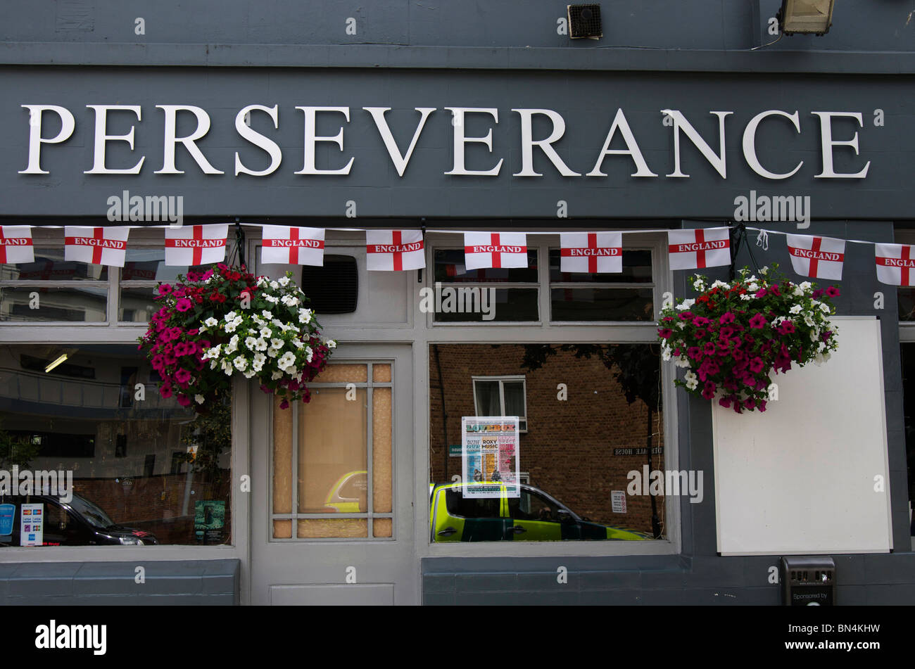 Pub avec persévérance de ligne français drapeaux et paniers suspendus de fleurs Banque D'Images