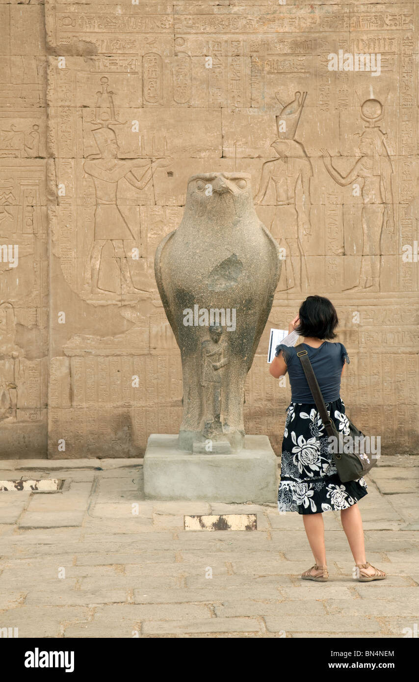 Tourisme une femme prise d'une photo d'une statue de l'ancien dieu égyptien, Horus, temple d'Edfou, Egypte Banque D'Images