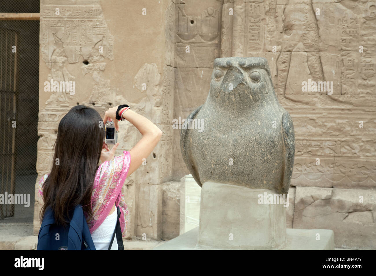 Woman prendre une photo d'une statue de l'ancien dieu égyptien Horus ; Temple d'Edfou, Egypte Banque D'Images