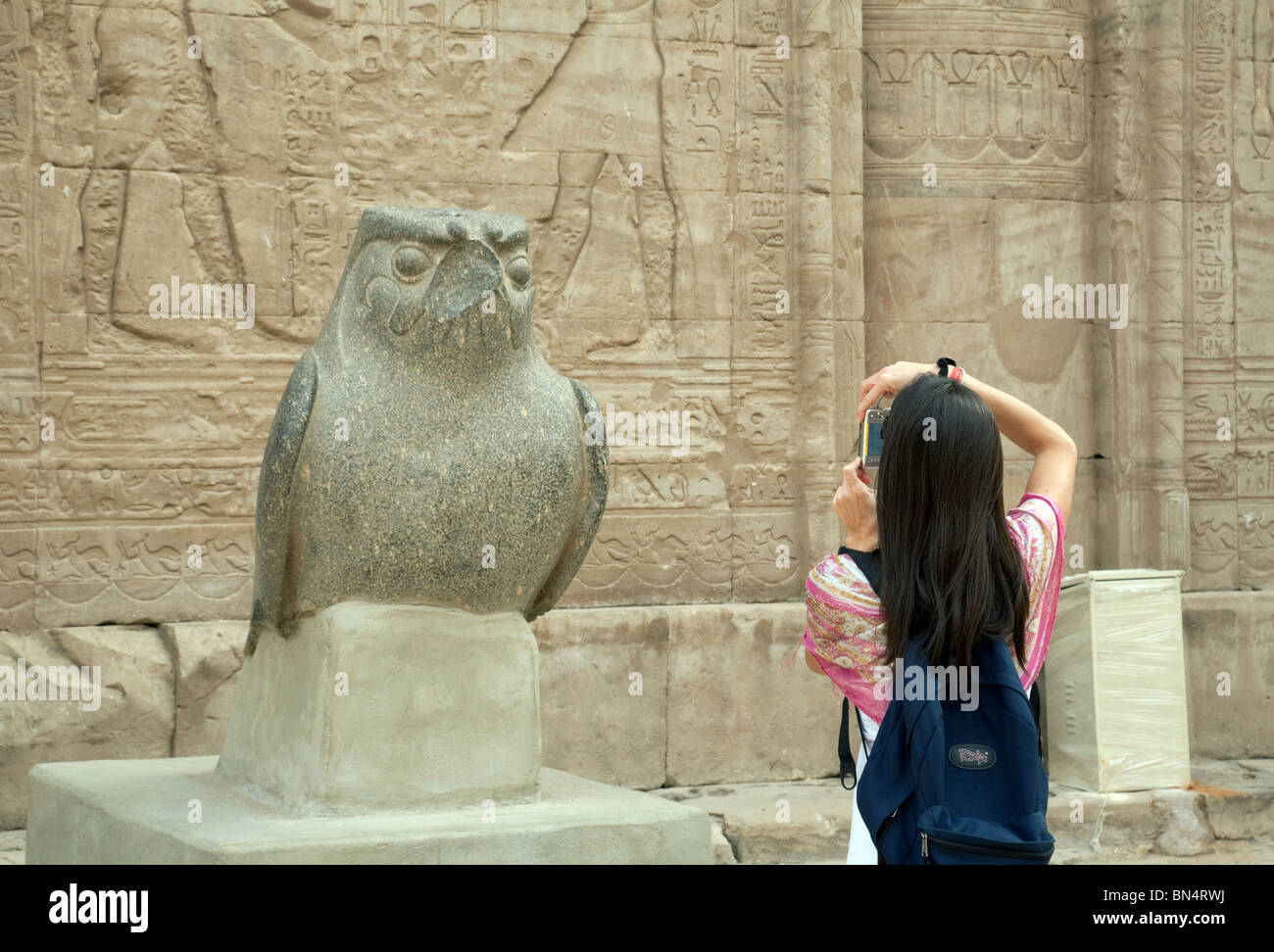 Woman prendre une photo d'une statue de l'ancien dieu égyptien Horus ; Temple d'Edfou, Egypte Banque D'Images