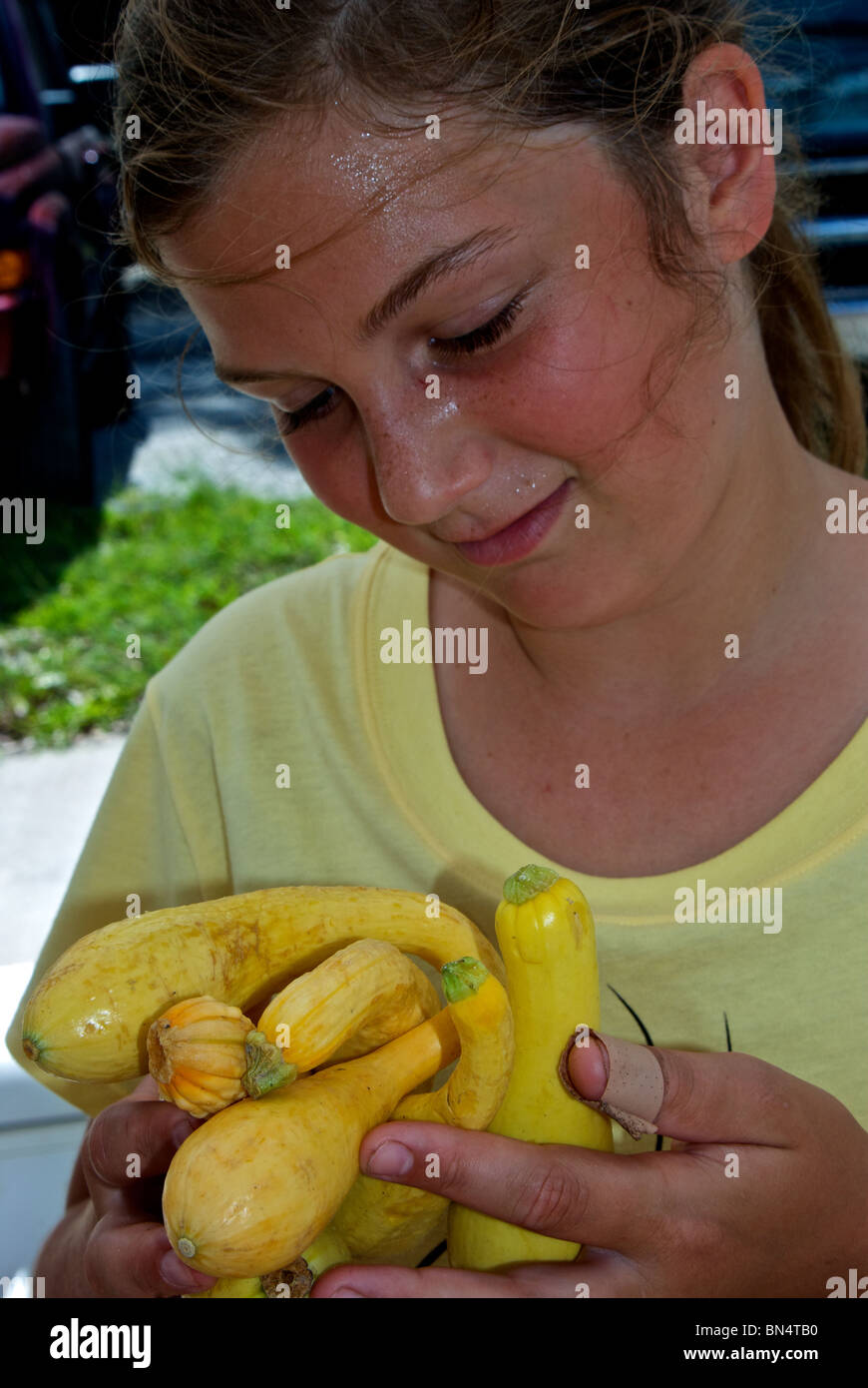 Young Girl holding poignée de courge jaune au marché de fermiers dans la région de Lake Charles LA Banque D'Images