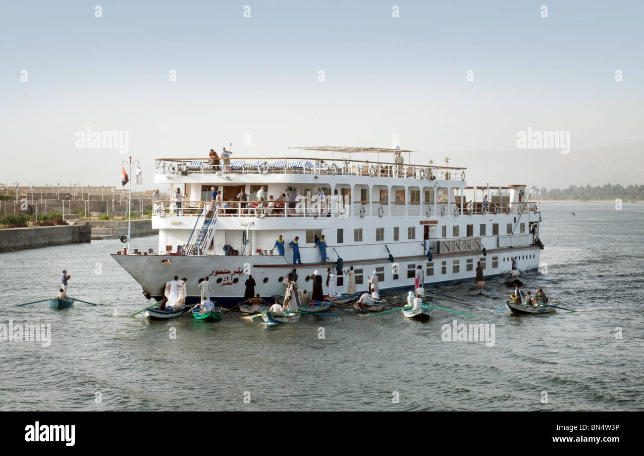 Un navire de croisière nil entouré par les commerçants dans les barques vendant des marchandises pour les touristes, Nil, à Esna, Egypte Banque D'Images