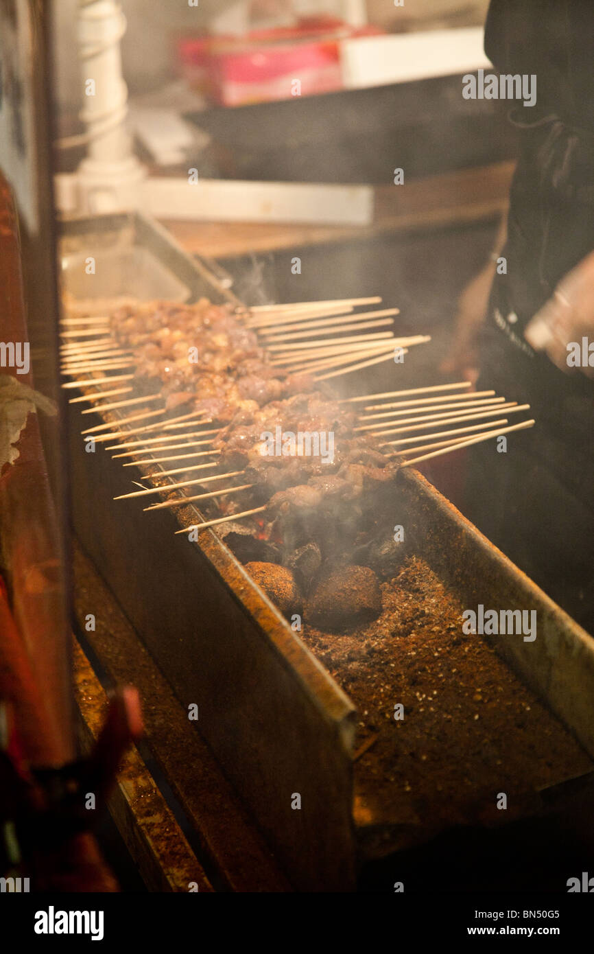 La viande sur un bâton dans un marché de nuit asiatique Stand alimentaire Banque D'Images