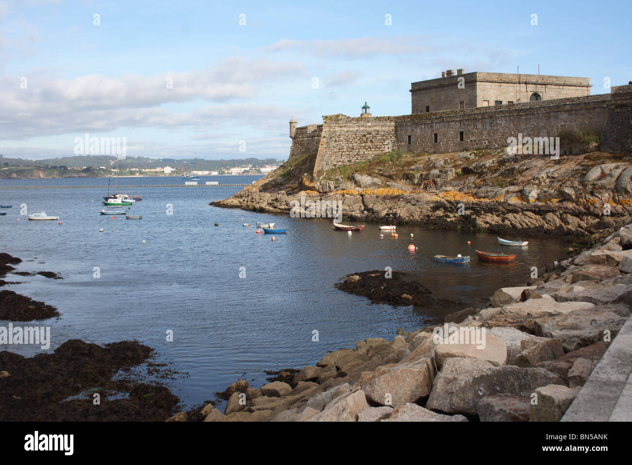 Le château de San Anton, en face de l'eau à La Coruna, La Corogne, Galice, Espagne, avec les bateaux de pêche amarrés dans bay Banque D'Images