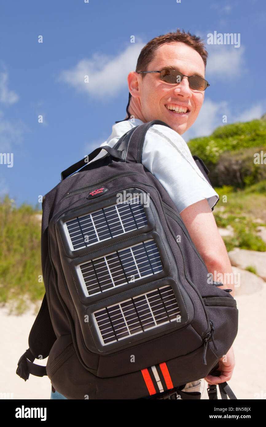 Un homme portant un sac à dos solaire. Les panneaux solaires peuvent être  utilisées pour recharger les téléphones portables et autres appareils  électriques Photo Stock - Alamy