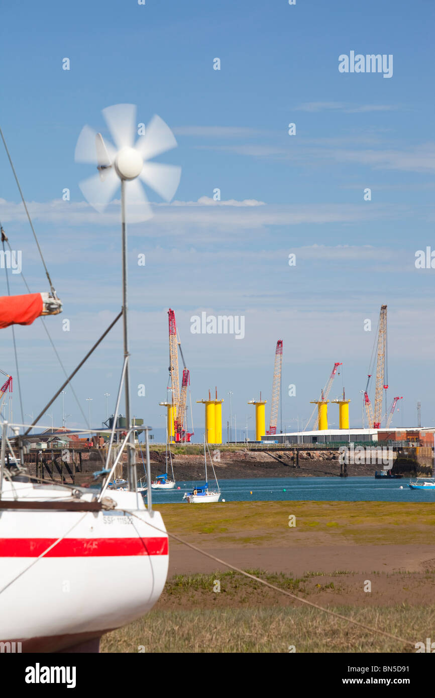 Un yacht avec une petite éolienne en face de la construction site pour Dong Energy's éoliennes en mer. Banque D'Images