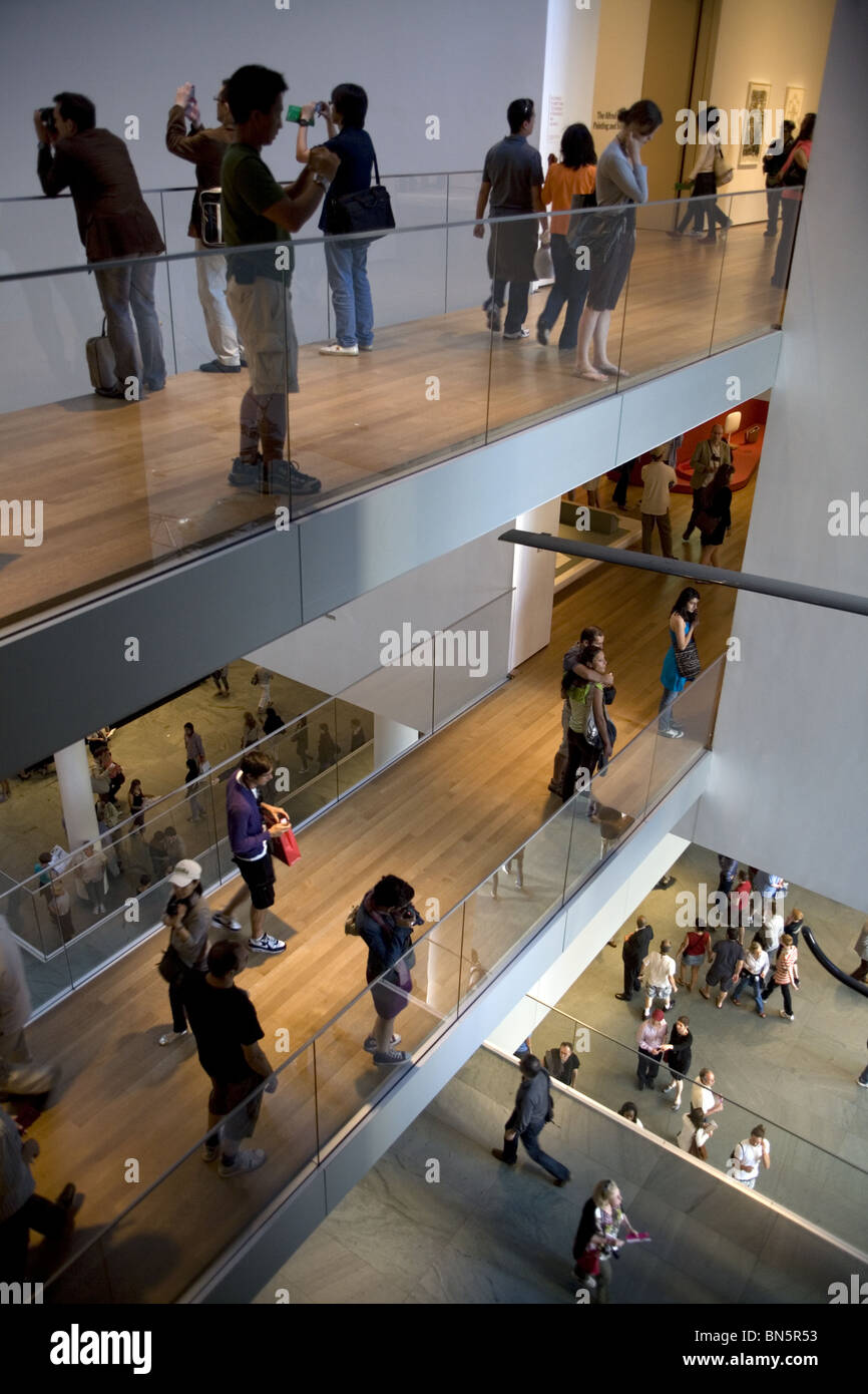 Les foules deviennent partie intégrante de l'architecture intérieure du Musée d'Art Moderne de New York. Banque D'Images