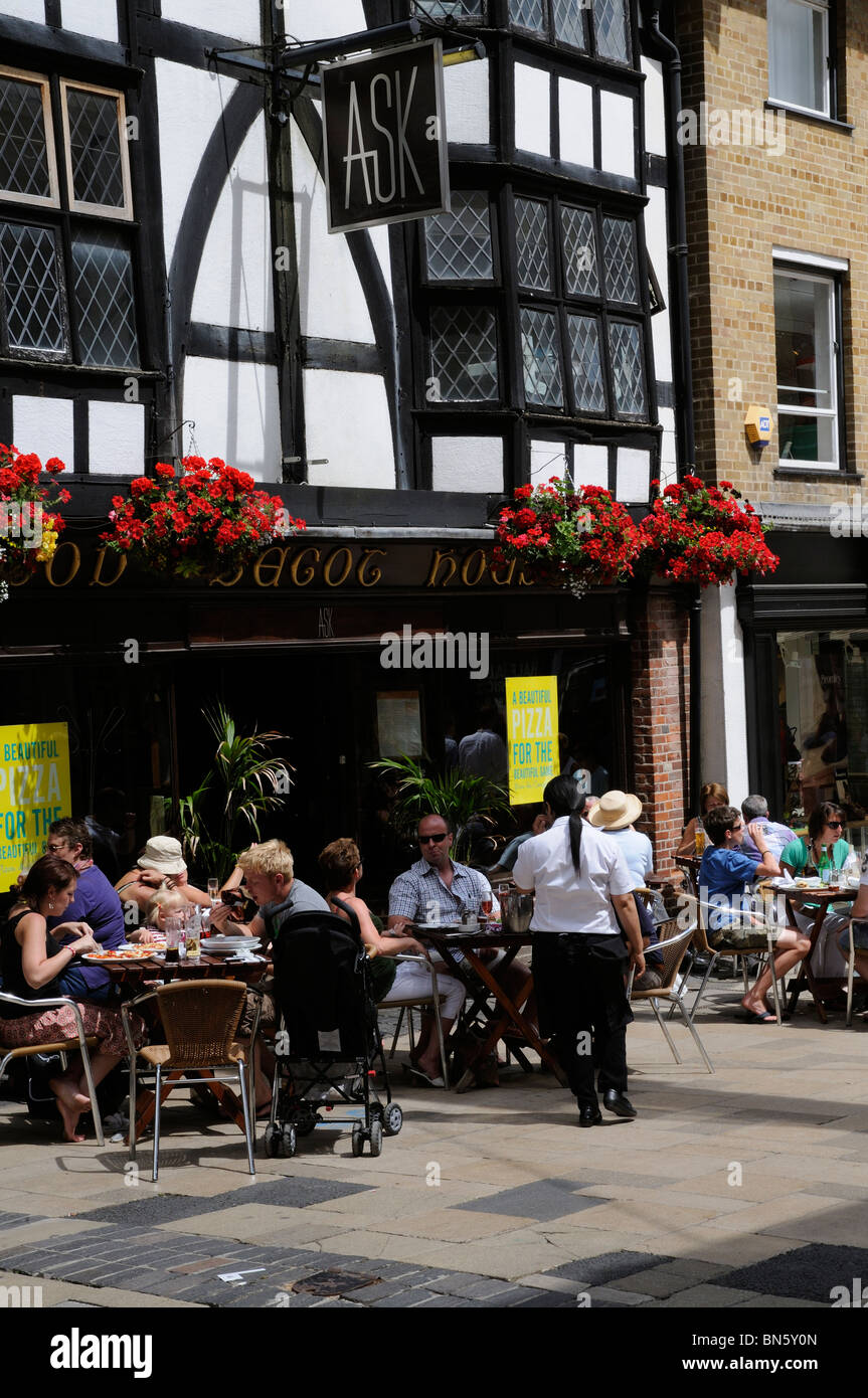 Poser restaurant diners boire et manger à des tables sur le trottoir High Street Winchester Hampshire UK Banque D'Images