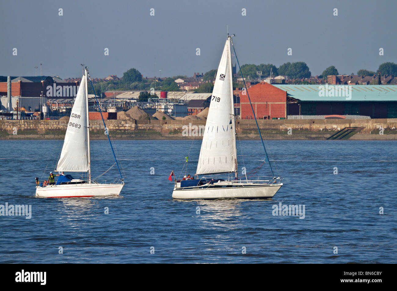 Deux petits bateaux à voile de compétition au fleuve Mersey sur une soirée ensoleillée. Banque D'Images