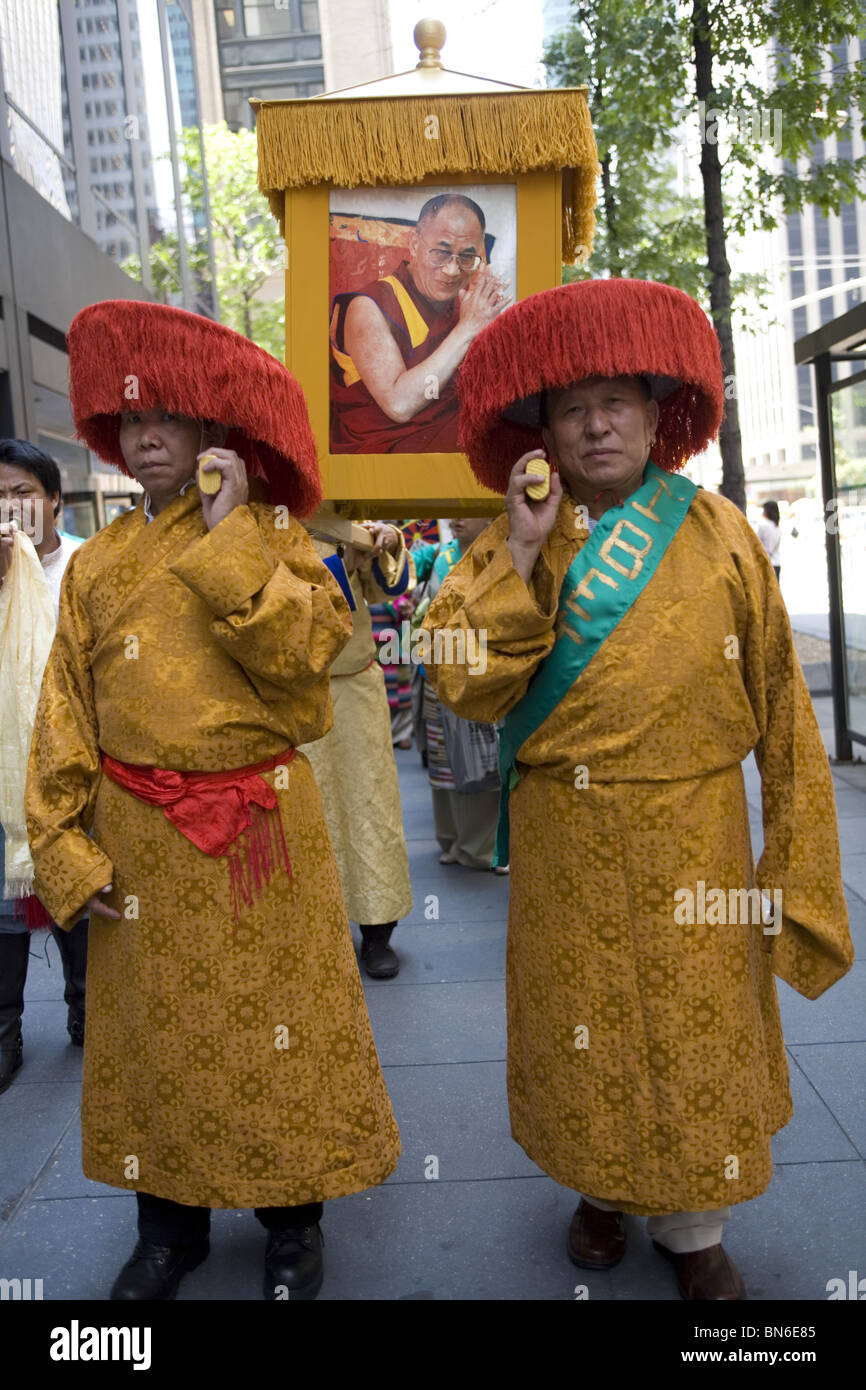 Les immigrants internationaux Parade à New York. Moines bouddhistes tibétains effectuer photos du dalaï-lama dans le respect de leur chef. Banque D'Images