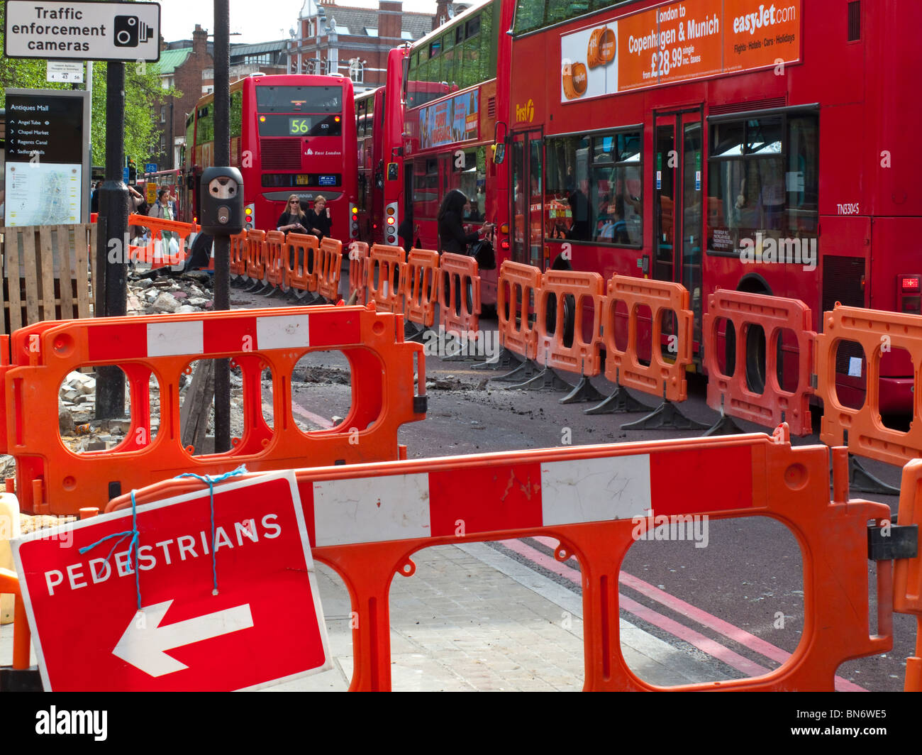 Les travaux routiers et de la chaussée avec des bus derrière dans la Street North Islington Londres Angleterre Royaume-uni Banque D'Images