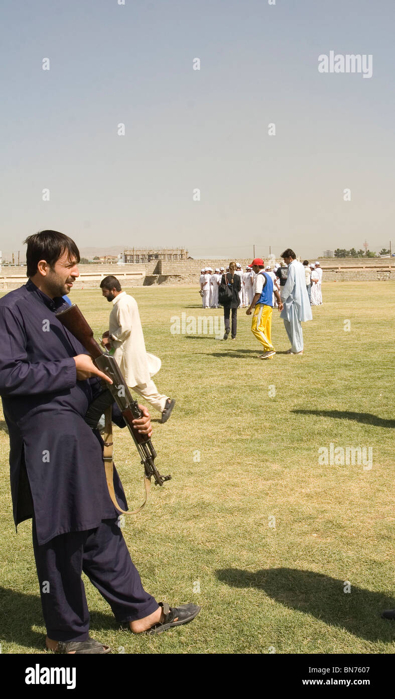 On apprend aux enfants comment jouer à Kaboul Afghanistan sous garde armée Banque D'Images