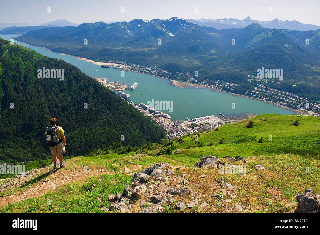 Un randonneur prend de l'avis de Gastineau Channel, Douglas Island, et le centre-ville de Juneau depuis le sommet de Mt. Juneau en Alaska Banque D'Images