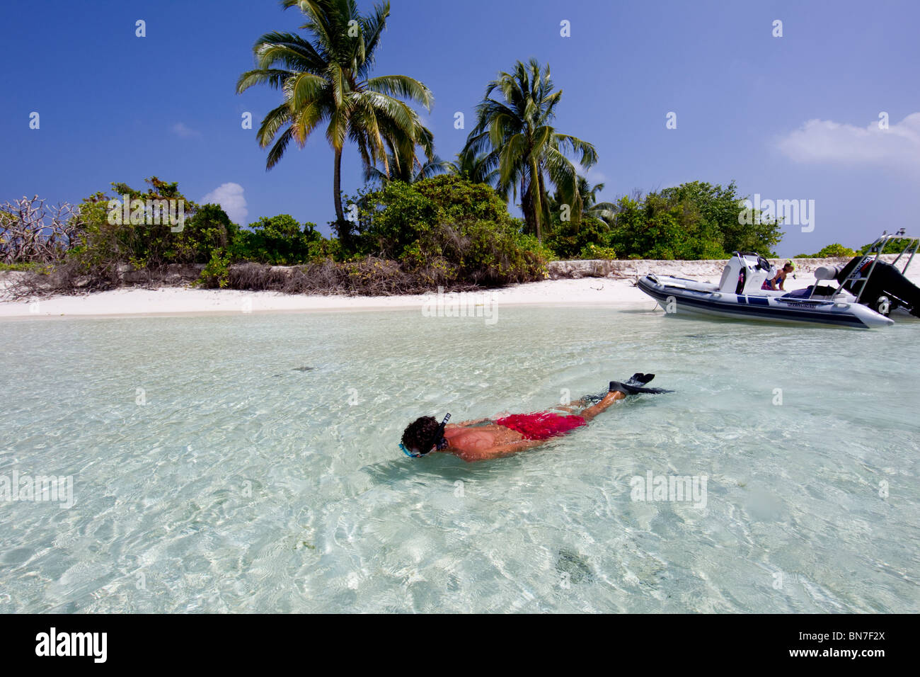 Snorkeler bénéficiant d'un atoll à distance dans la chaîne, de l'océan Indien aux Maldives Banque D'Images