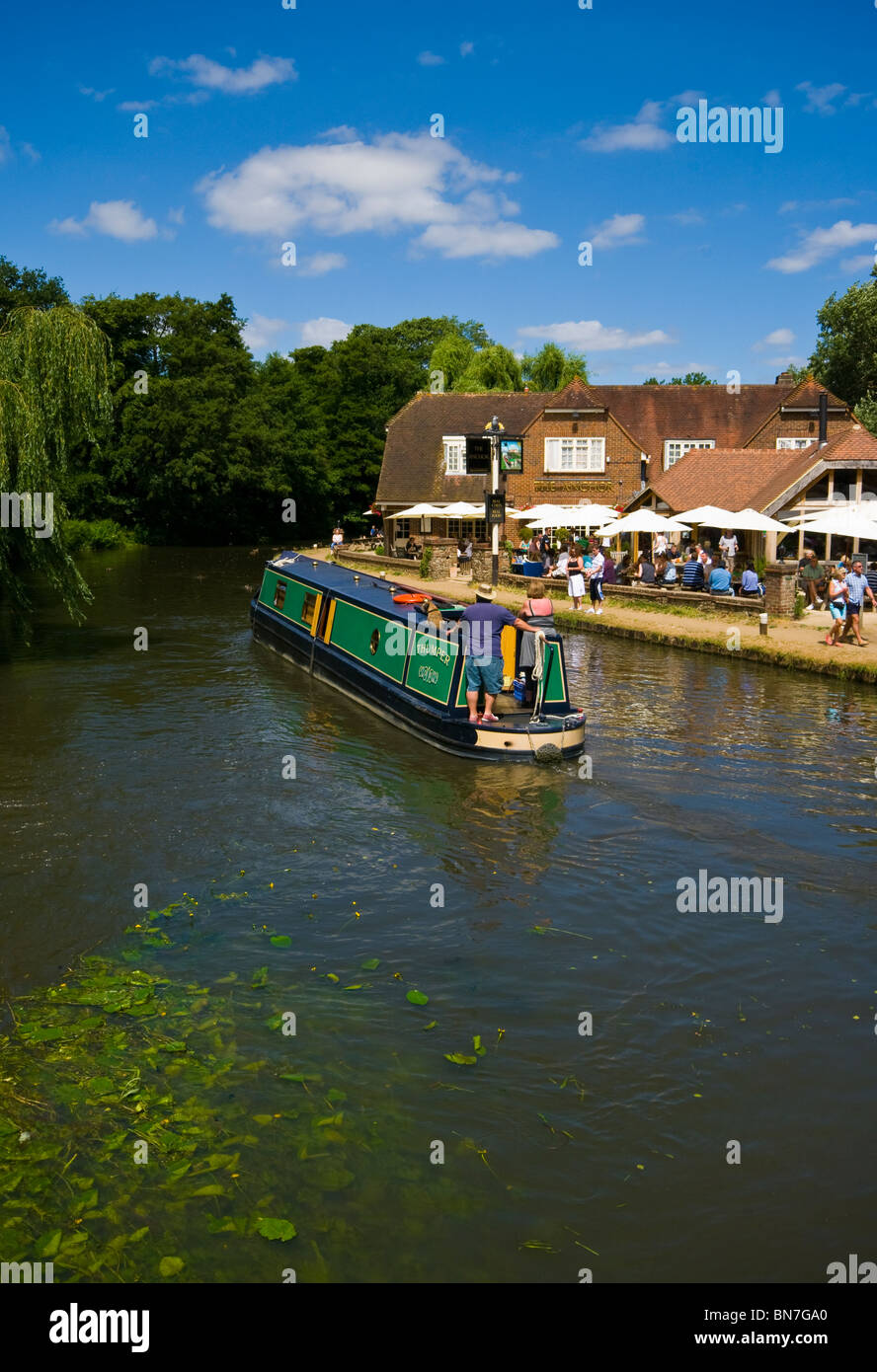 Un étroit canal boat 15-04 passant le Anchor Pub sur la rivière Wey Pyrford Surrey England Banque D'Images