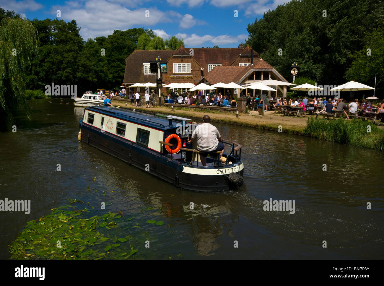 Un étroit canal boat 15-04 passant le Anchor Pub sur la rivière Wey Pyrford Surrey England Banque D'Images