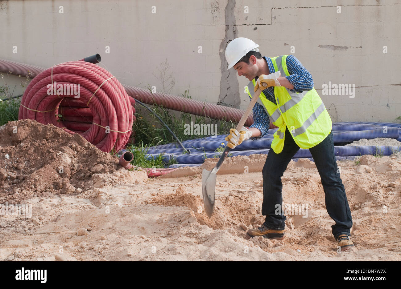 Hispanic construction worker digging Banque D'Images