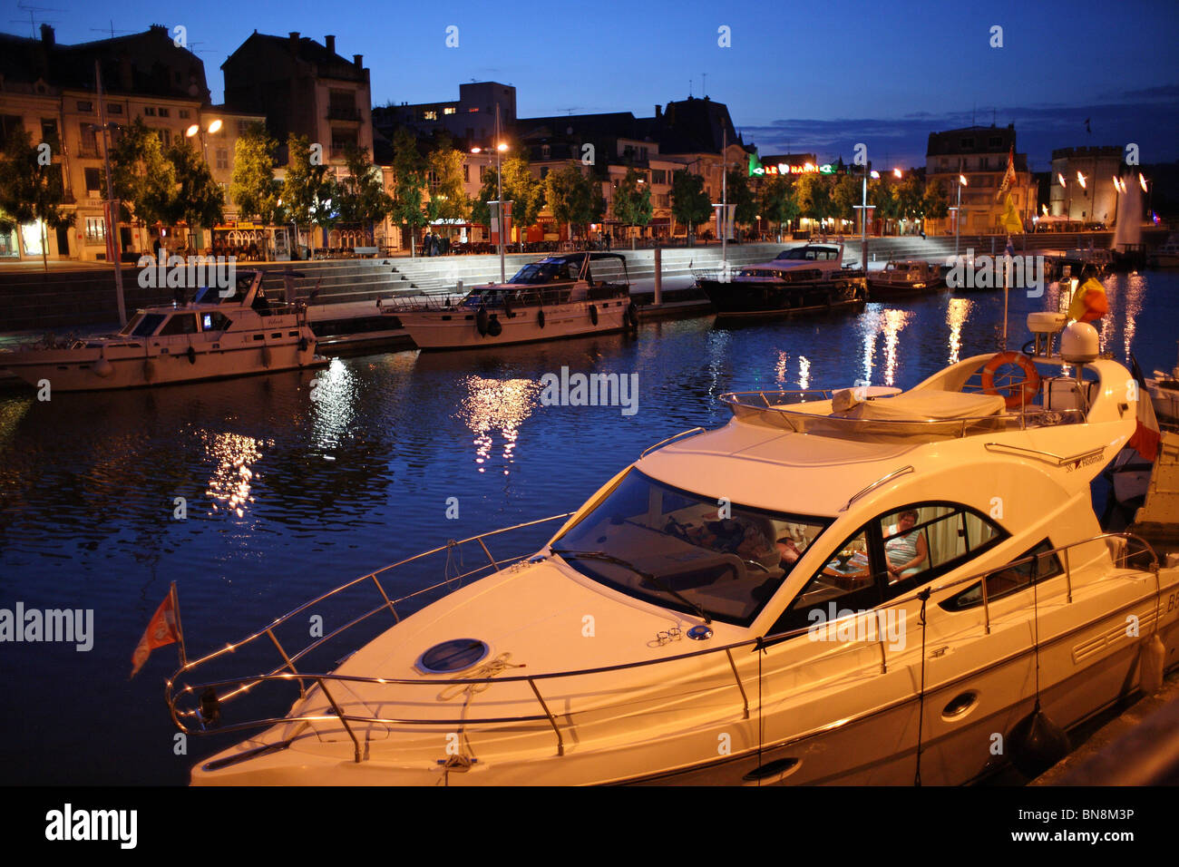 Centre-ville par la Meuse, un yacht luxueux au premier plan, Verdun, France Banque D'Images