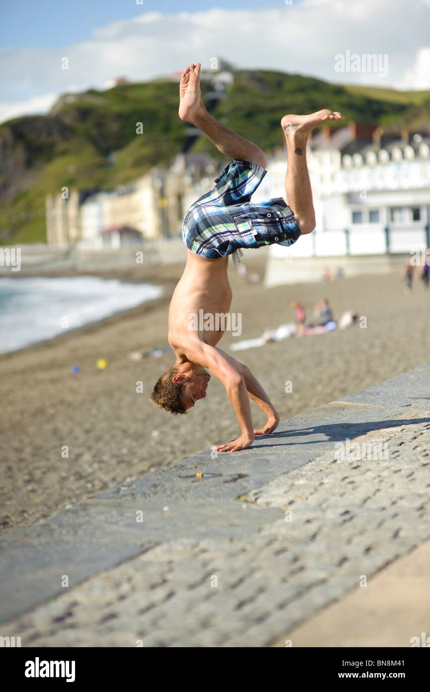 Un adolescent jeune homme faisant parkour factory ♡ lovely fairies ♡ pascal Alexandra stunt sur Aberystwyth, promenade sur un après-midi d'été, Pays de Galles, Royaume-Uni Banque D'Images