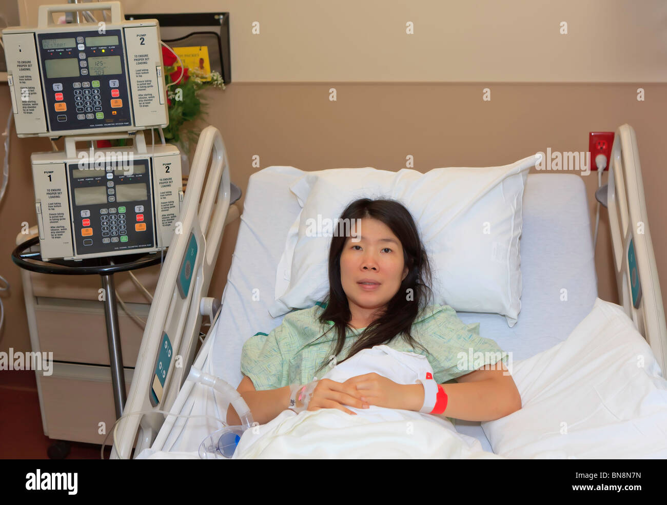Asian Woman in hospital Bed Banque D'Images