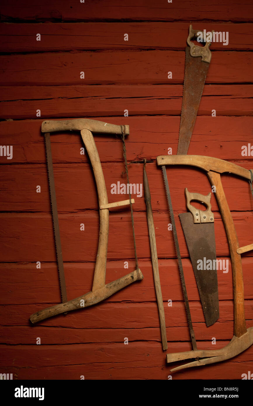 Mur de bois rouge avec de vieilles scies de décoration Banque D'Images