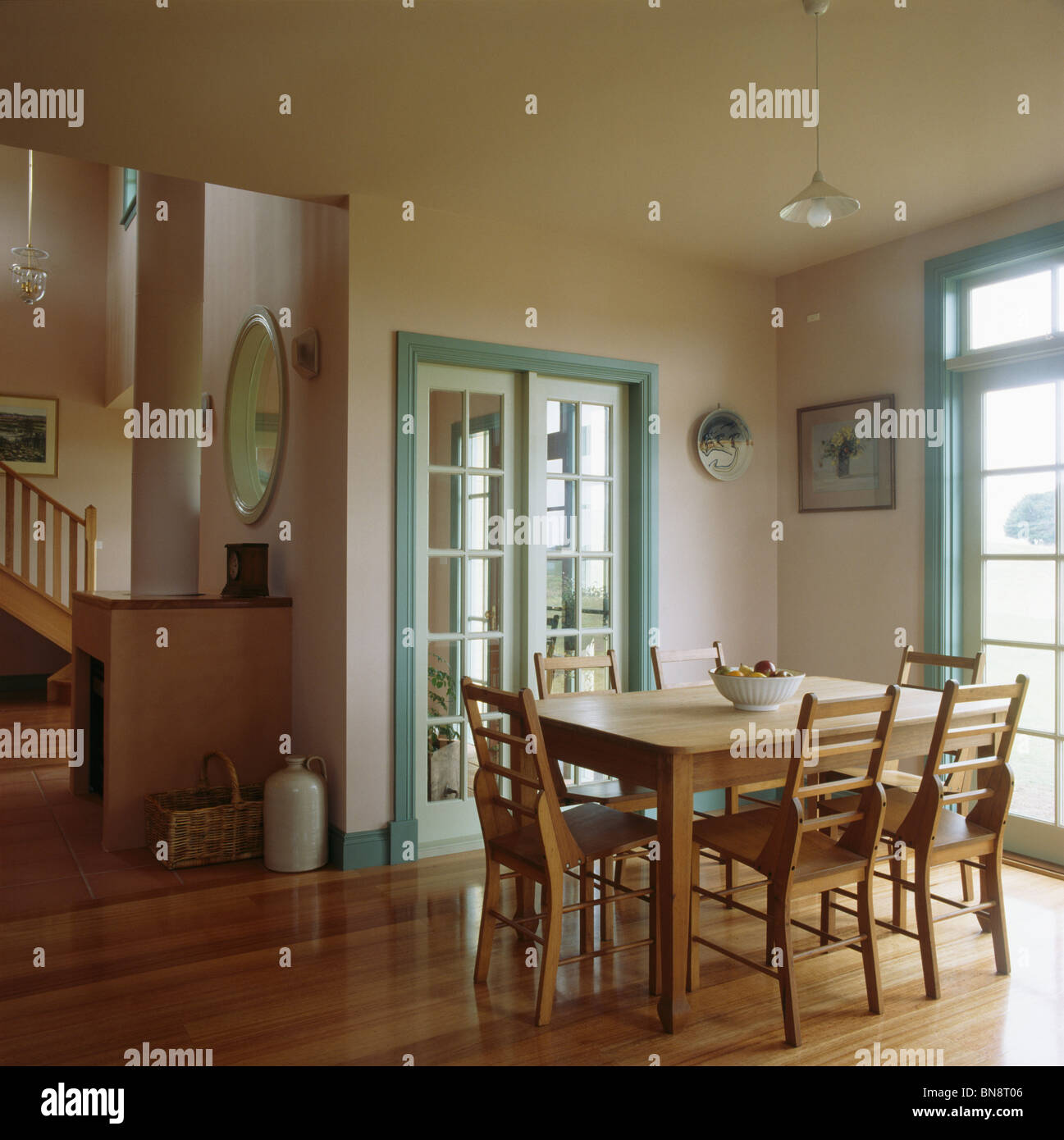 Table et chaises en bois dans la salle à manger moderne avec des portes-fenêtres turquoise Banque D'Images