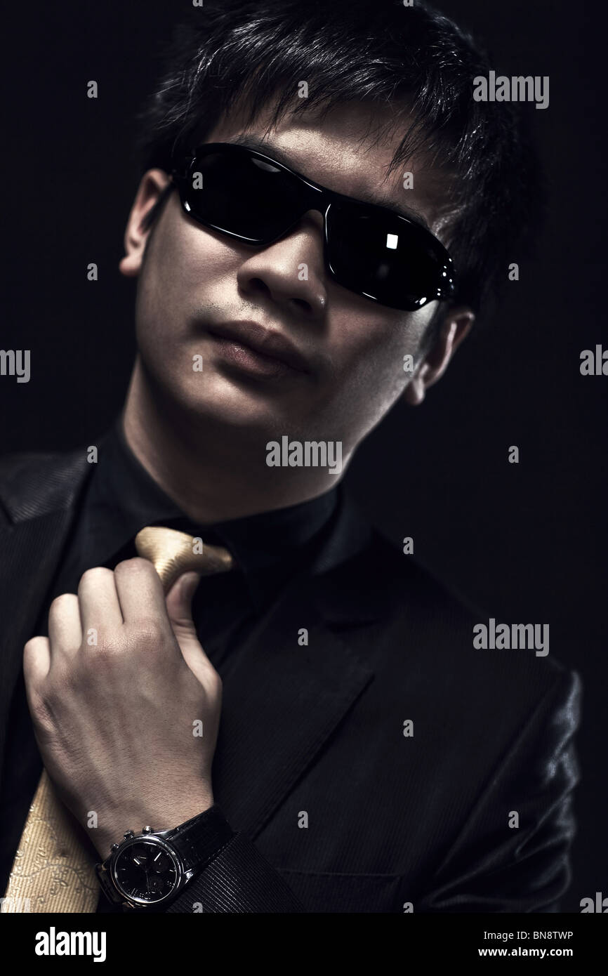 L'homme japonais cool lunettes en portrait. Des couleurs sombres. Banque D'Images