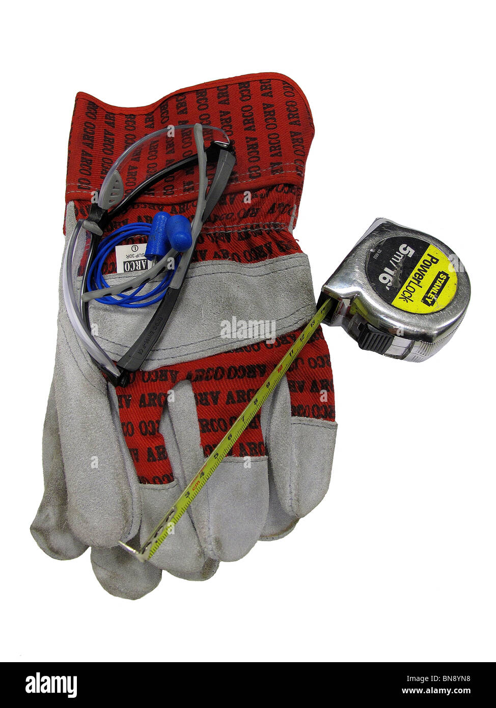 Gants de sécurité Lunettes de sécurité et des bouchons d'oreille aux côtés d'un ruban de mesure pour les équipements de protection individuelle Banque D'Images