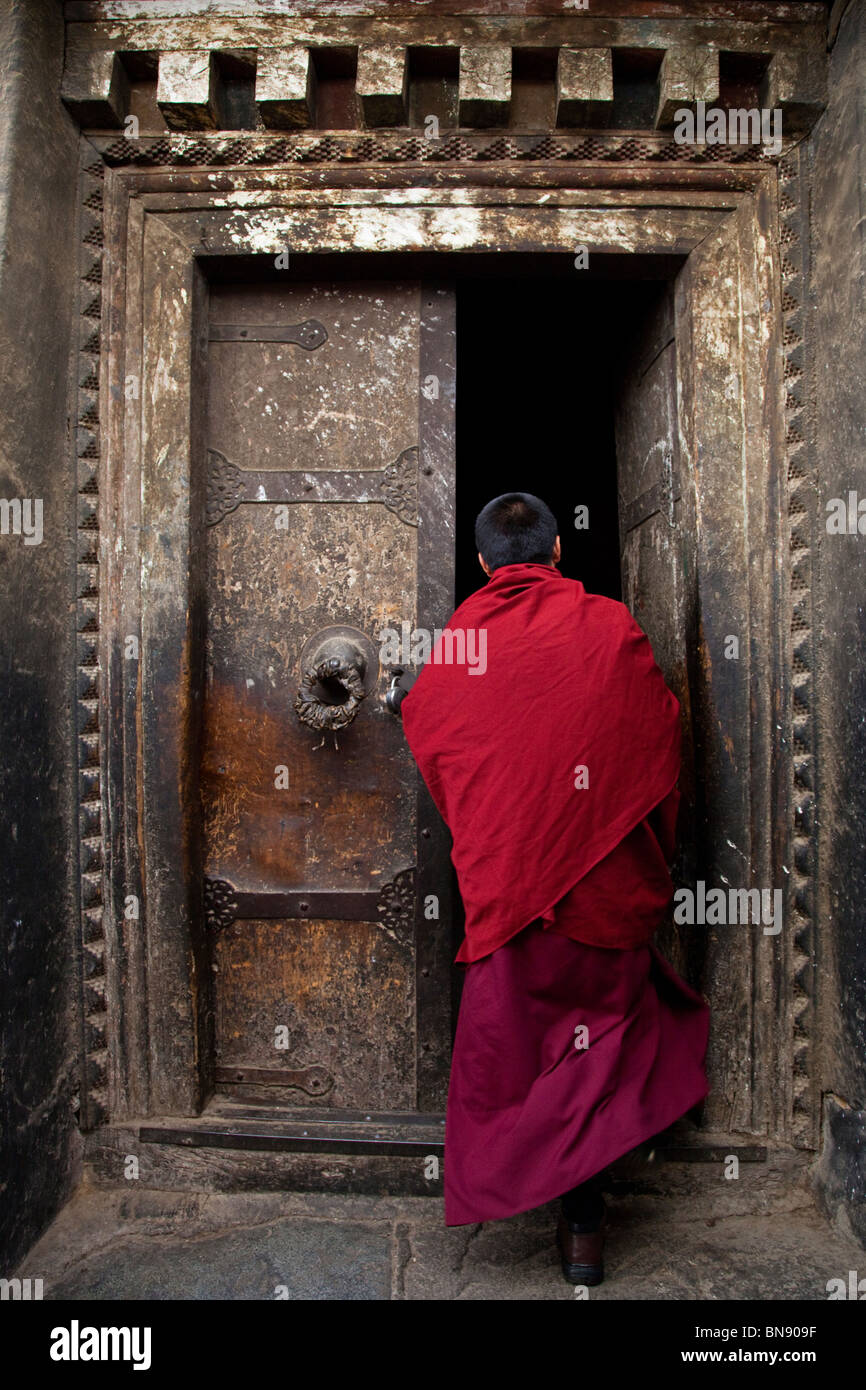 Moine dans une porte à monastère de Sera à Lhassa, Tibet Banque D'Images