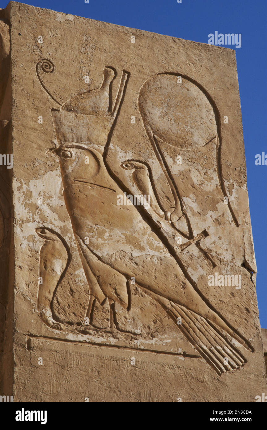 Disque solaire avec serpent (cobra) avec l'ankh autour de son cou et Falcon avec double couronne plus d'un cobra. Le soulagement. Banque D'Images