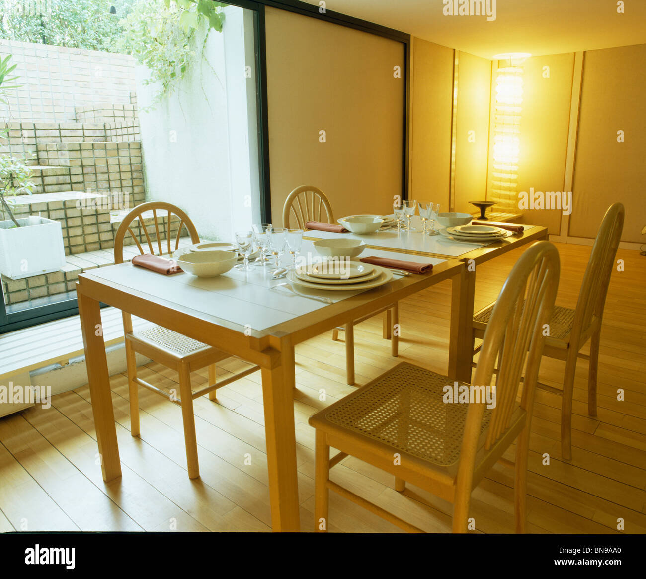 Table et chaises en bois clair en face de grande fenêtre dans la salle à manger moderne Banque D'Images
