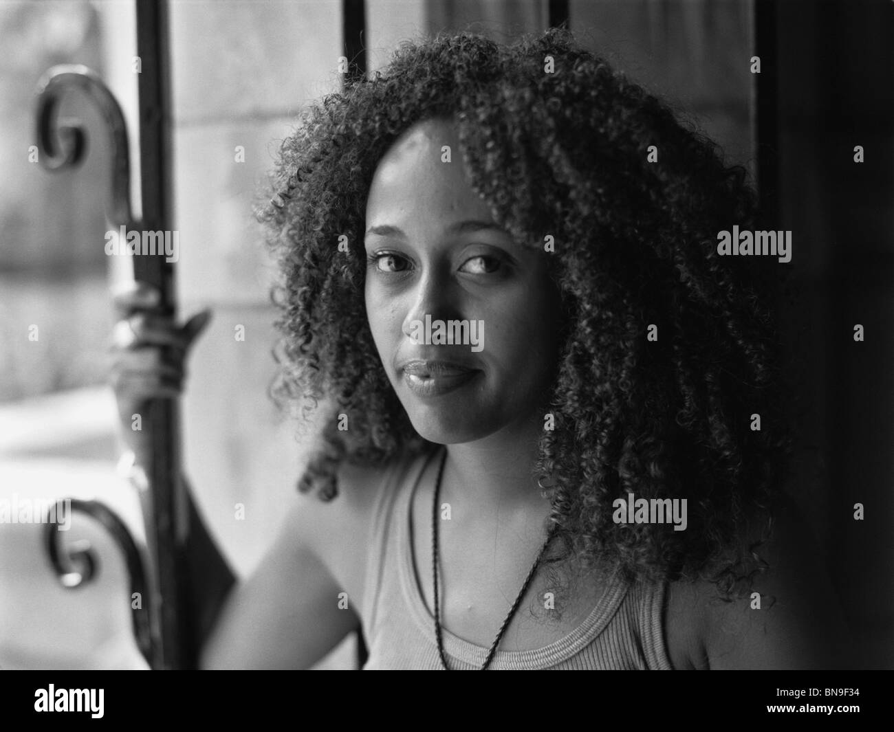 Mixed Race woman standing near window Banque D'Images