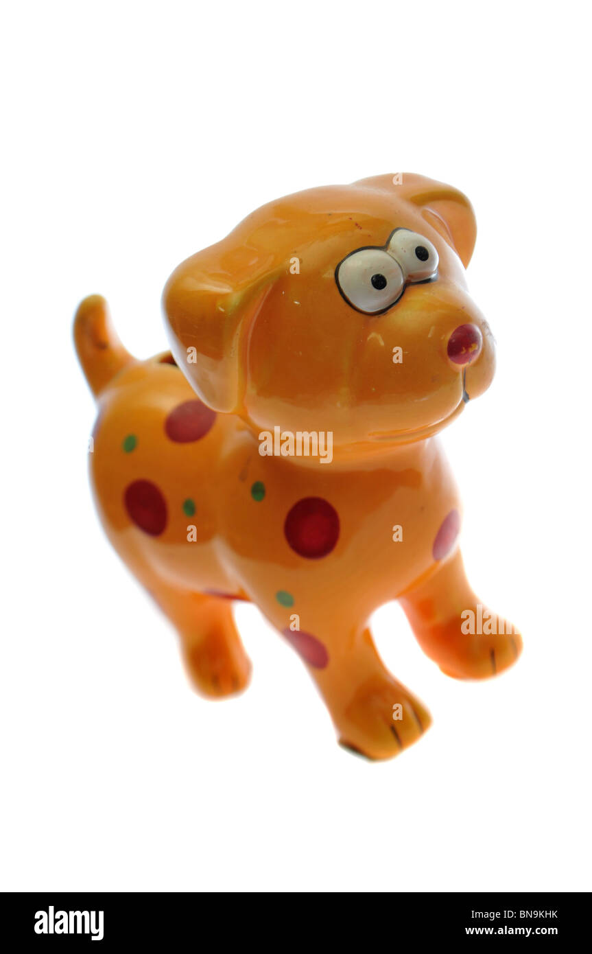 Chien miniature en verre jaune isolé sur blanc. Il a des taches rouges et verts Banque D'Images