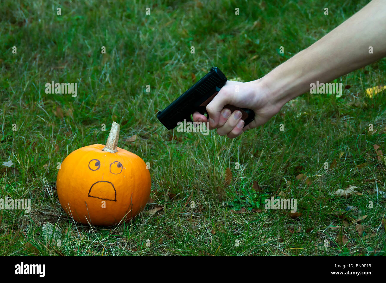 Citrouille terrifiés se tenait à une arme. Au revoir l'Halloween. Banque D'Images