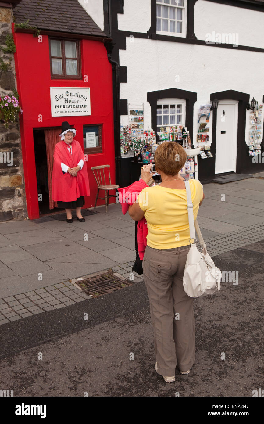 Pays de Galles, Gwynedd, Conway, touristes photographiant femme en costume gallois à l'extérieur de la Grande-Bretagne est plus petite maison Banque D'Images