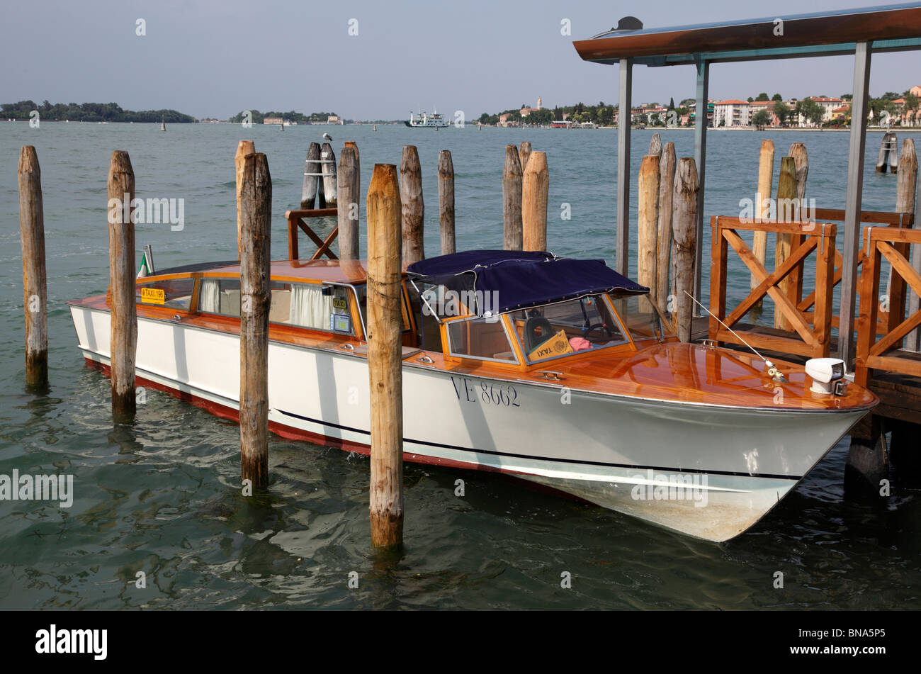 Un taxi de l'eau mouillée contre des poteaux au Lido Venise Italie Banque D'Images