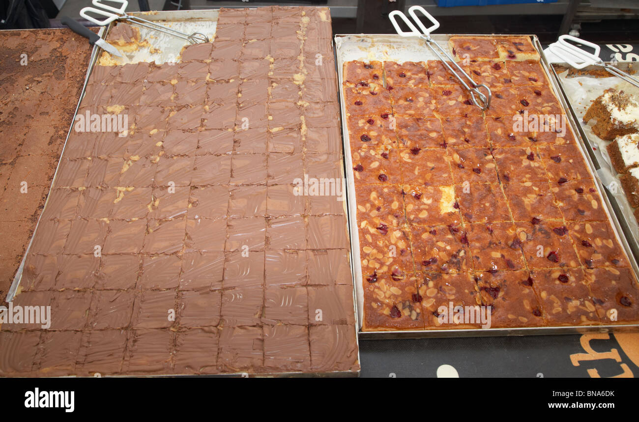 Dalle de grandes tranches de cuire des gâteaux sur le bac d'un décrochage à un marché au Royaume-Uni Banque D'Images