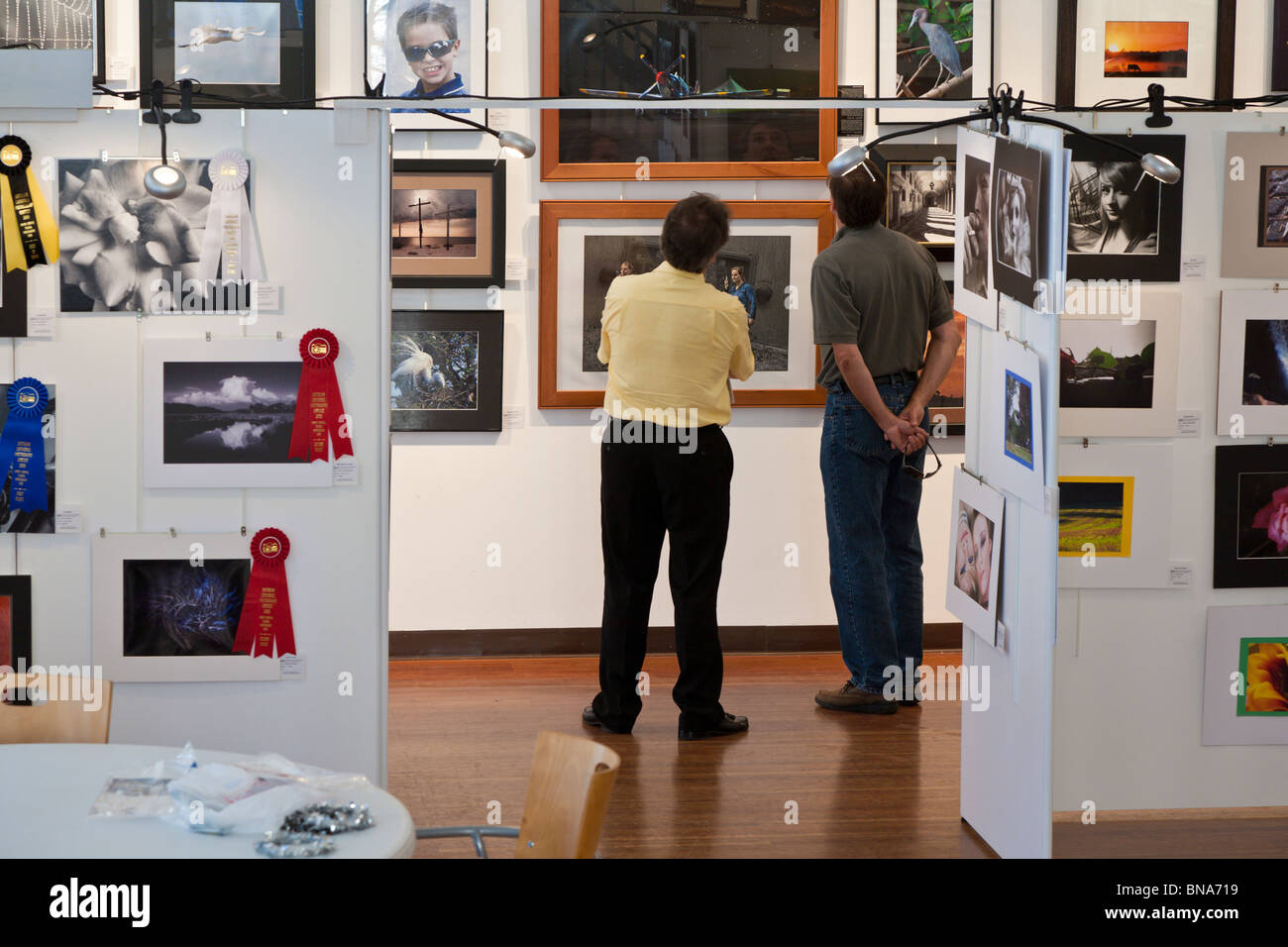 Les visiteurs d'une galerie d'art étude une exposition photographique à Brick City Center for the Arts, au centre-ville d'Ocala, Floride Banque D'Images