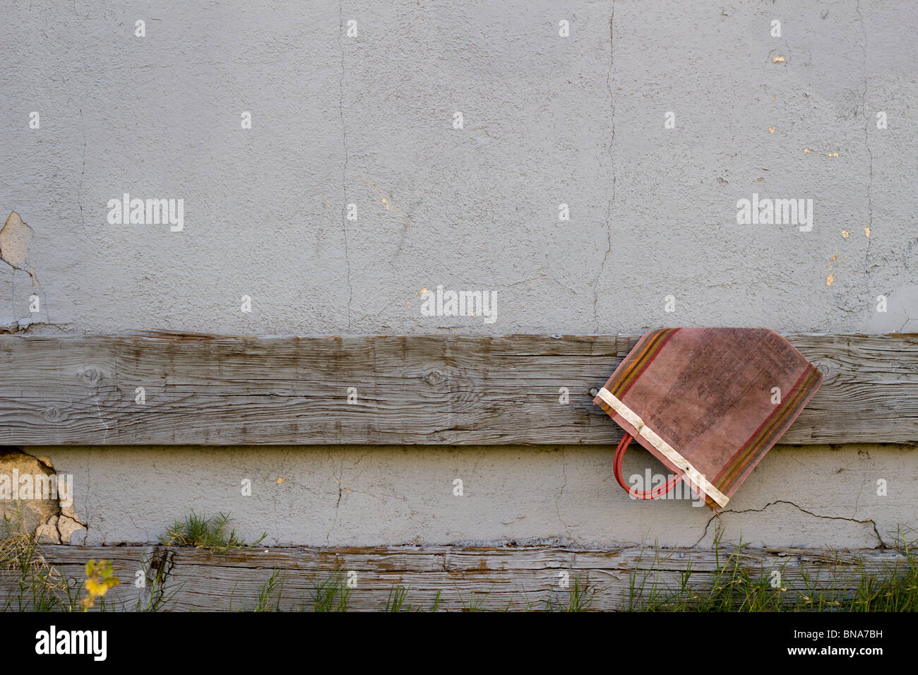 Un sac à main se bloque à l'abandon sur un vieux mur. Banque D'Images