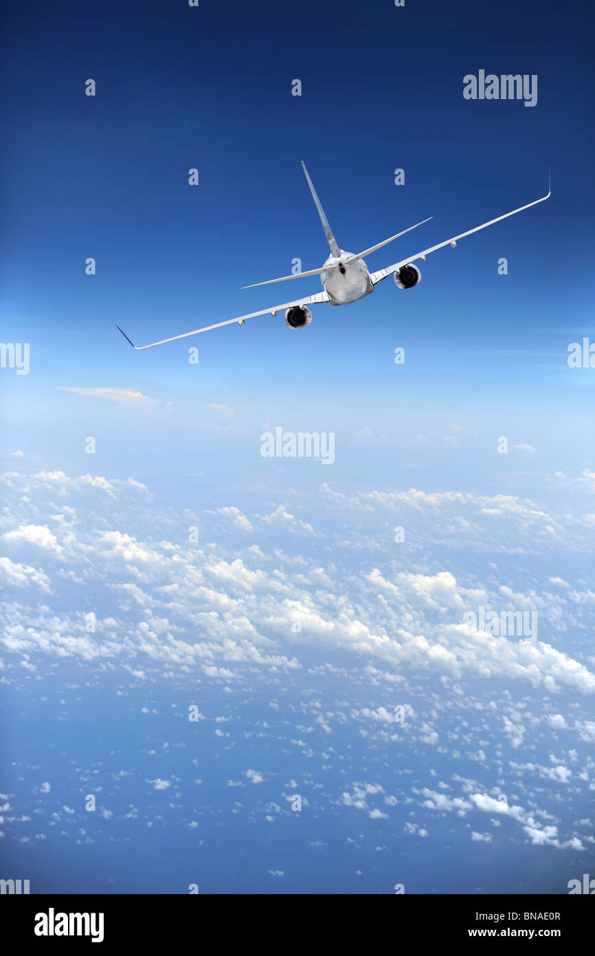 Avion de ligne en vol avec les nuages dans la distance Banque D'Images