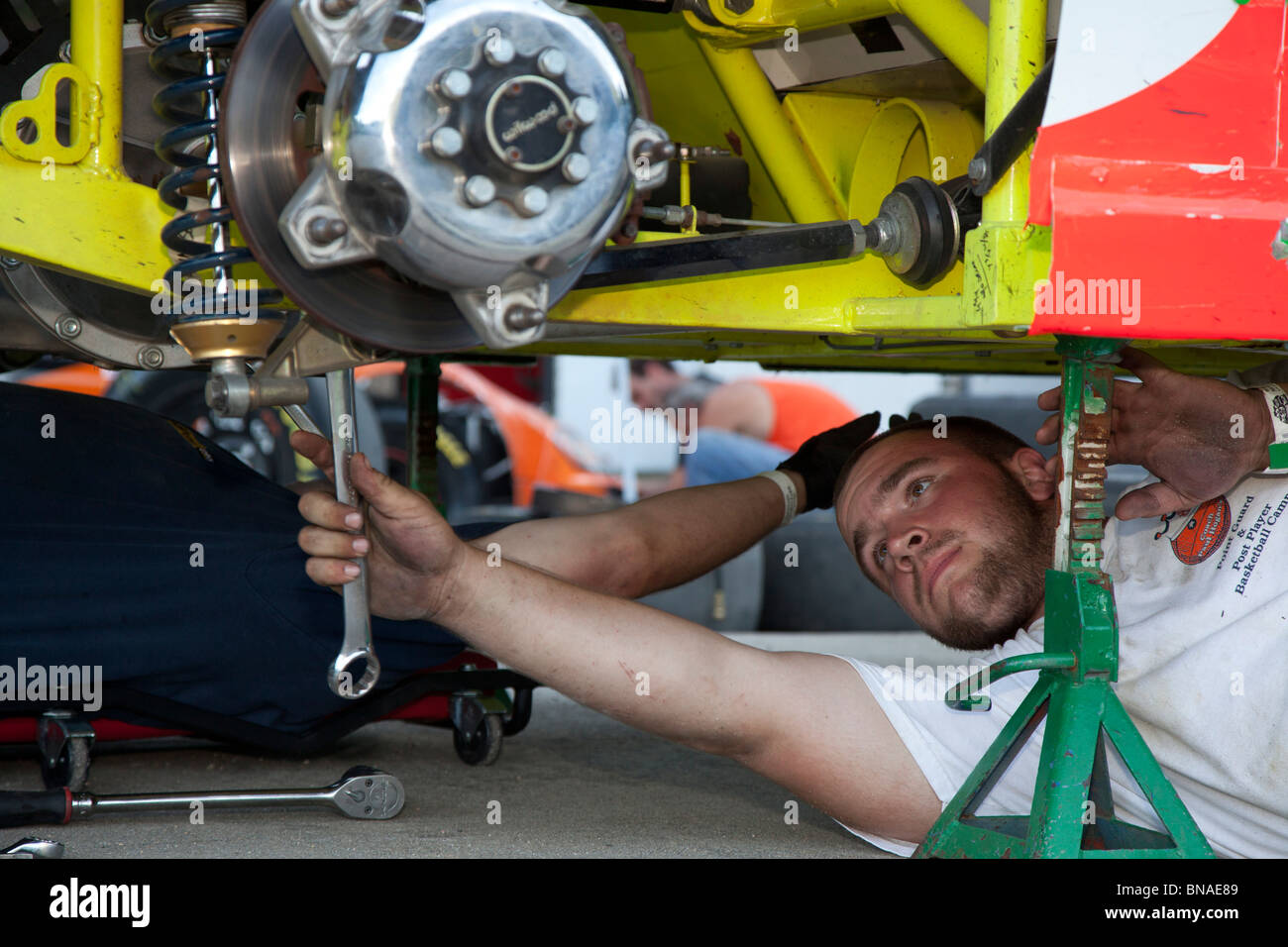 Woodstock, New Hampshire - un mécanicien travaille sur une voiture dans les stands pendant les courses de voitures à White Mountain Motorsports Park. Banque D'Images